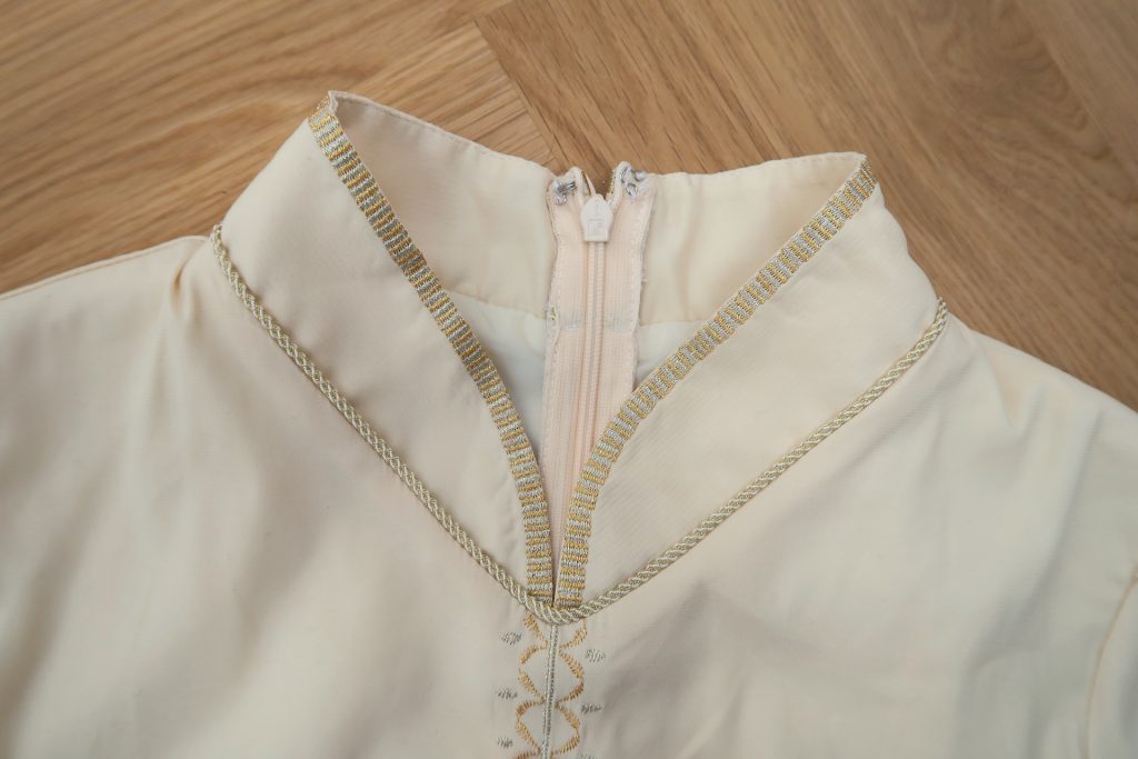 Detail trim and golden and silver embroidery collar of the shirt