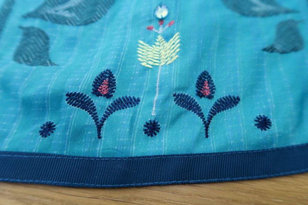 Embroidery Detail around the hem of the skirt with tulips and rhinestones